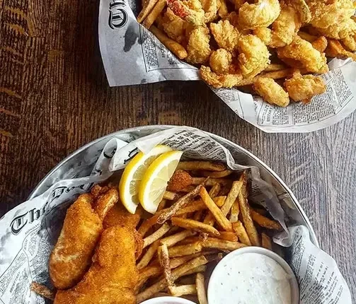Overhead shot of two baskets filled with fried fish and seafood.