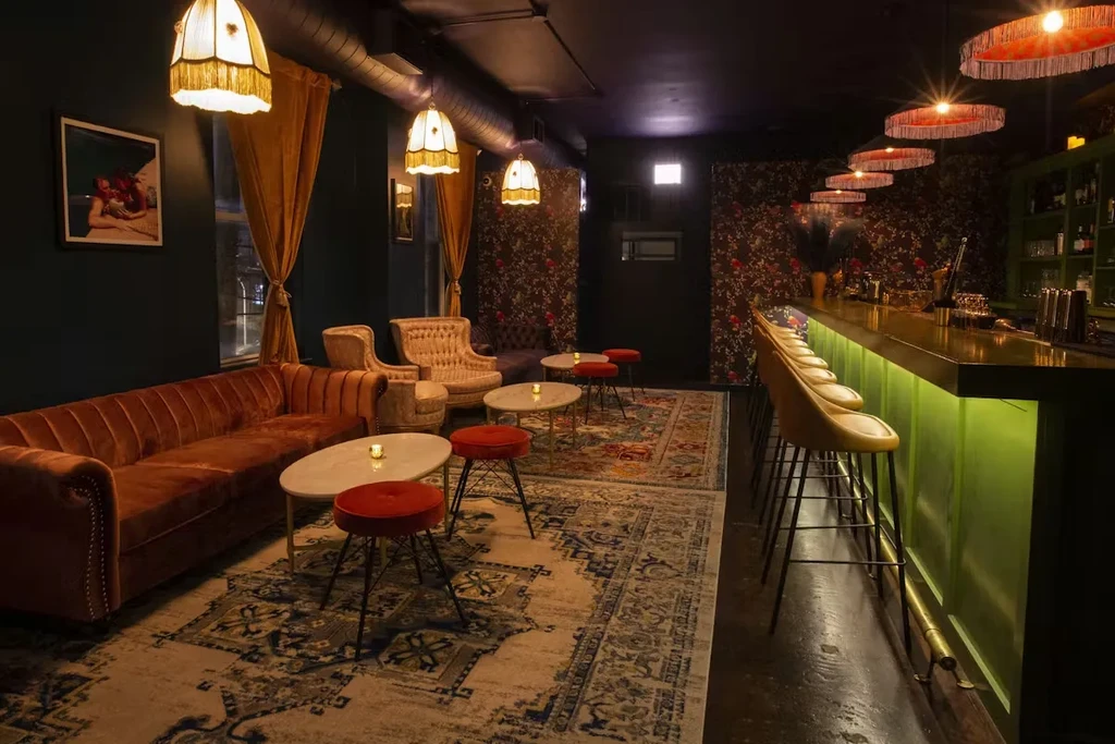Interior of a stylish bar with velvet seating and a lime green bar.