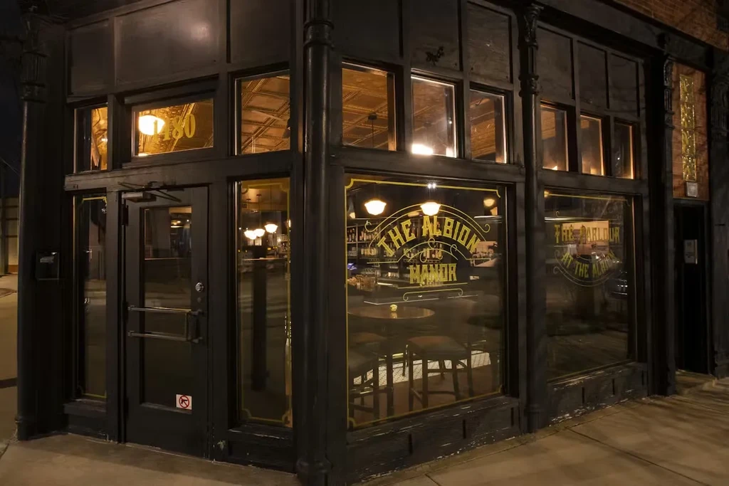 Exterior of The Albion Manor restaurant and bar at night.