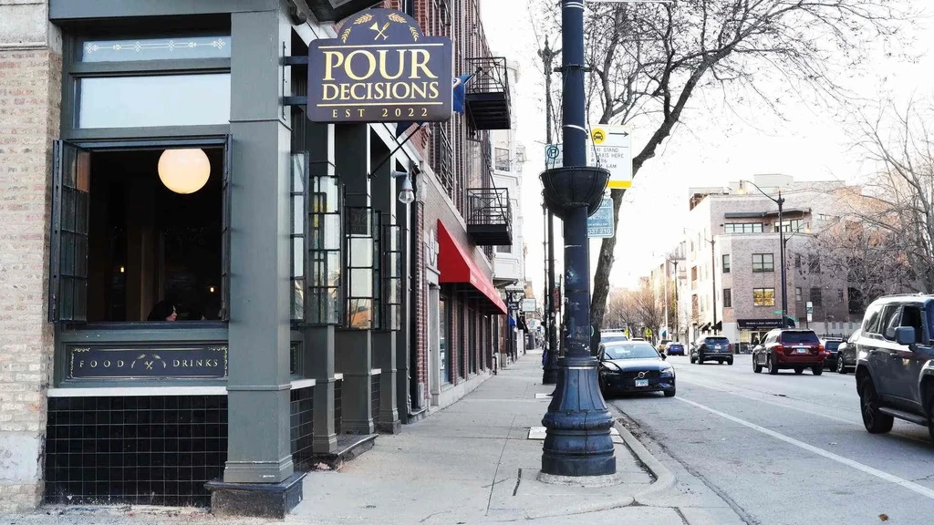 "POUR DECISIONS EST 2022" restaurant exterior with "FOOD / DRINKS" sign.