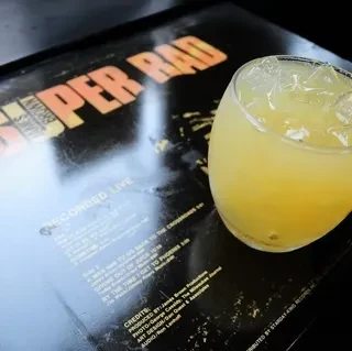 Drink with ice on a "SUPER RAD" record album cover.