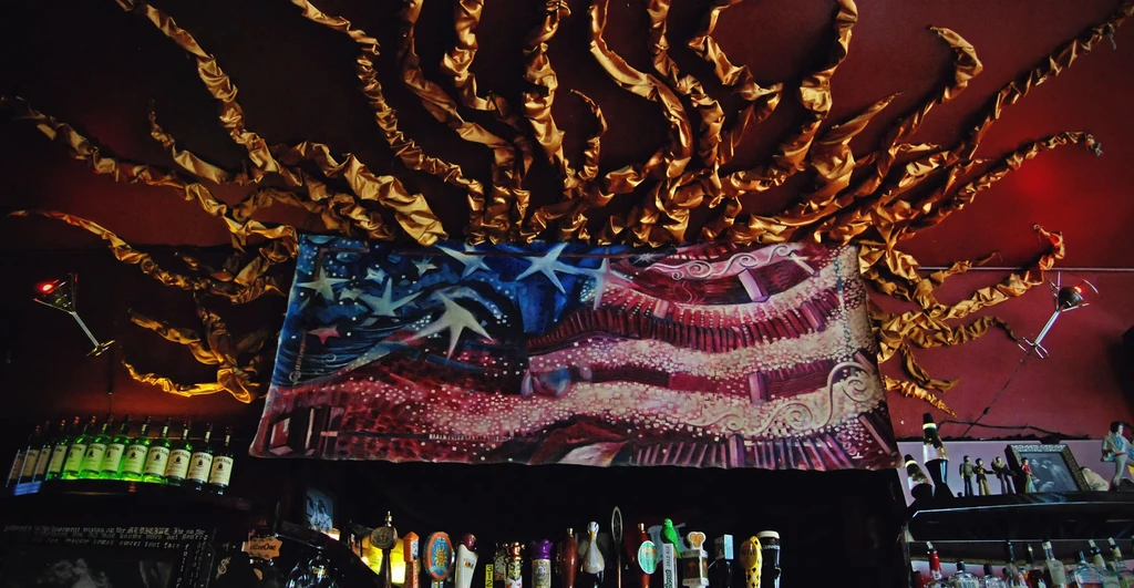 Abstract American flag and Jameson bottles on bar ceiling.