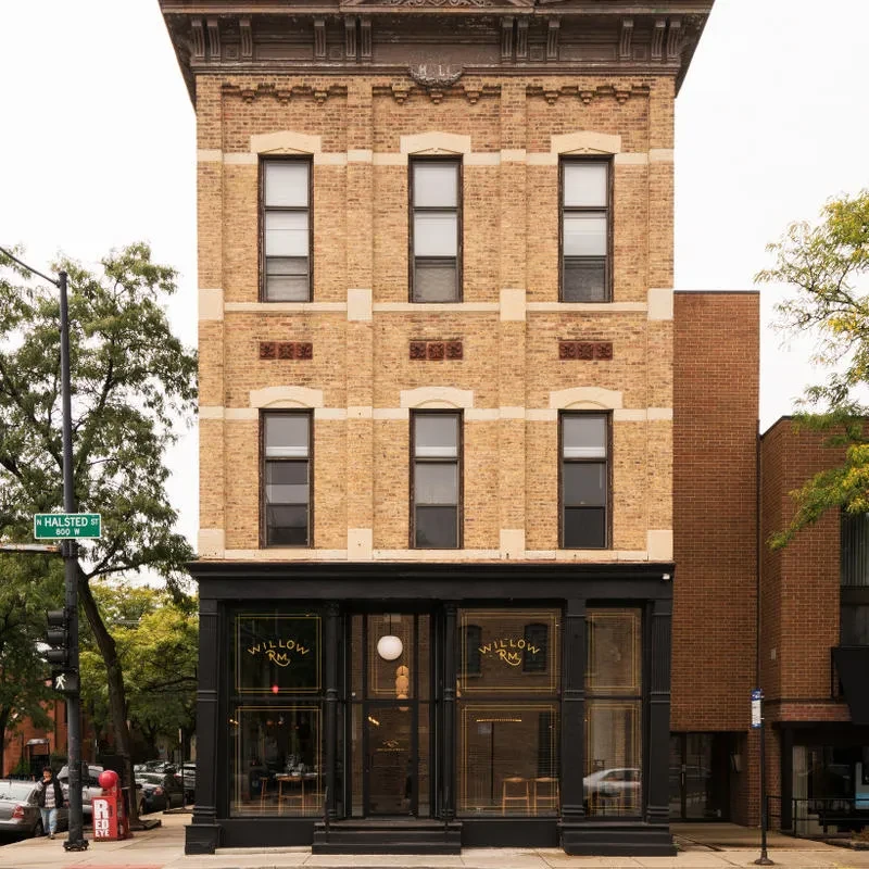 Exterior of a four-story brick building housing "Willow Rm" restaurant.