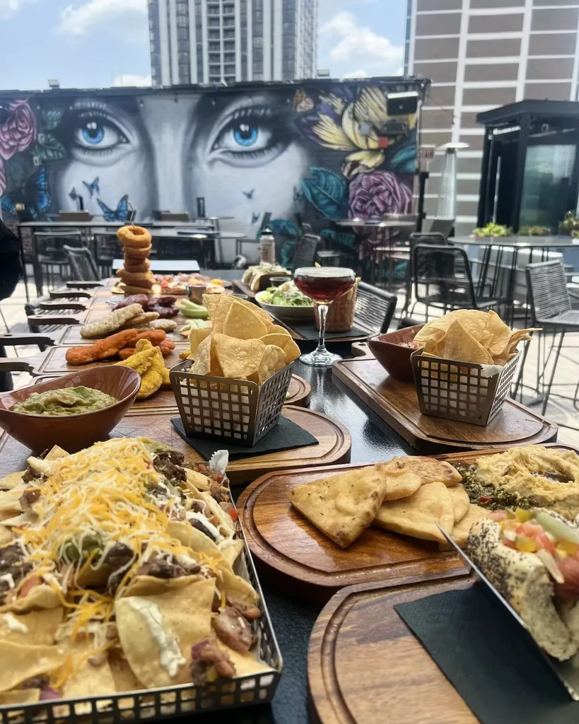 Nachos, chips, and appetizers on a rooftop table with city views.