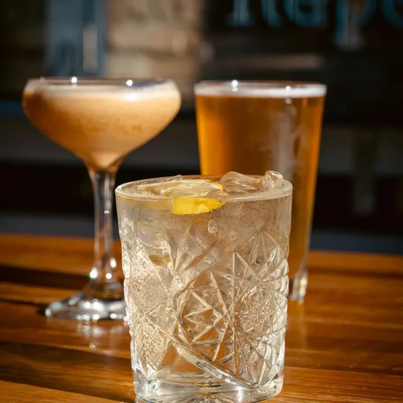 Three alcoholic beverages, including a beer, cocktail, and gin and tonic.