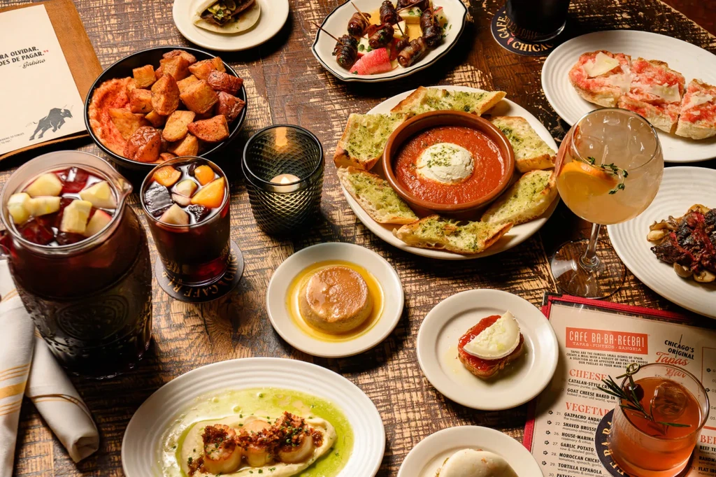 High-angle shot of a rustic table laden with plates of tapas.