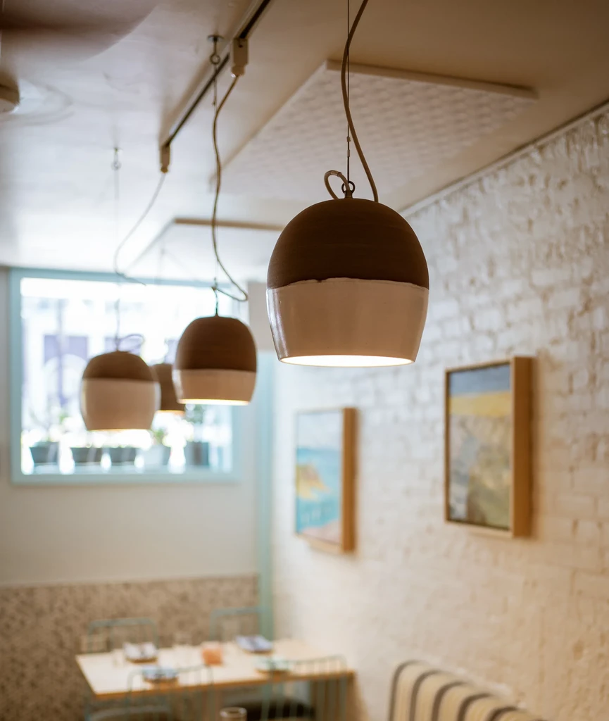 Modern pendant lights illuminate a cozy restaurant interior.