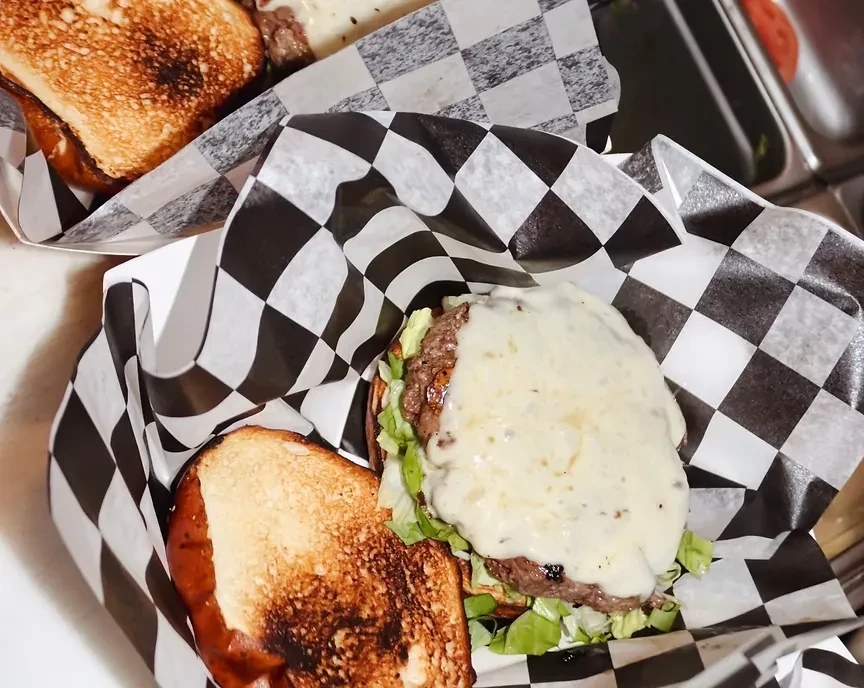Overhead shot of an open-faced burger with melted cheese.