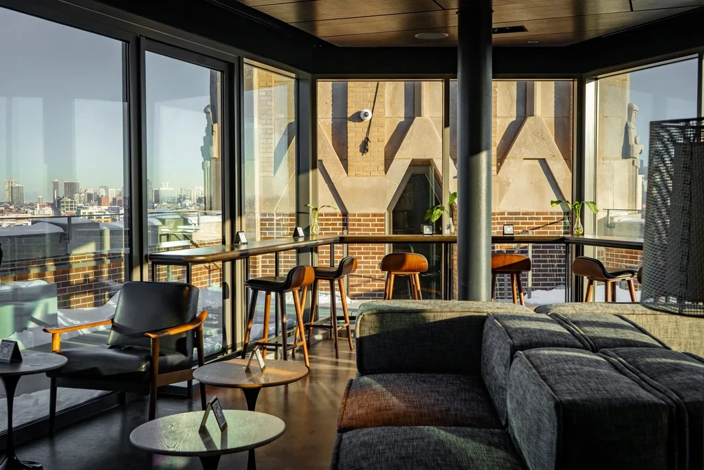 Modern bar interior with city views and various seating options.