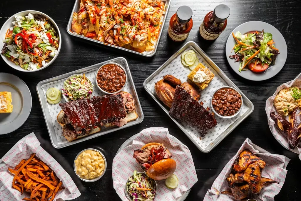 Overhead shot of a barbecue spread with ribs, chicken, and sides.