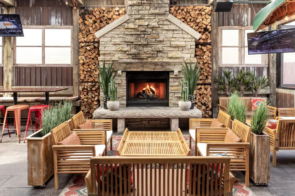 Restaurant interior with fireplace, seating, flat-screen TVs, and canoe.