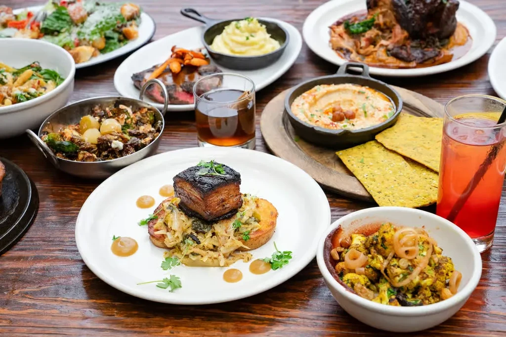 Rustic table laden with a variety of artfully arranged dishes and drinks.