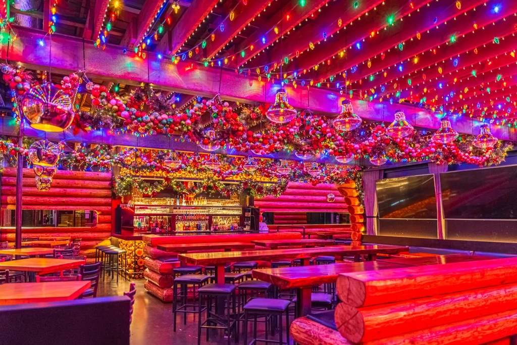 Festive restaurant interior with a bar, colorful lights, and disco balls.