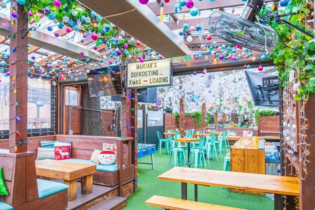 Festive restaurant interior with colorful holiday decorations and casual seating.