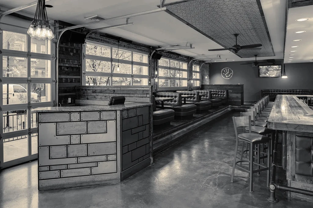 Black and white photo of a restaurant interior with booths and bar.