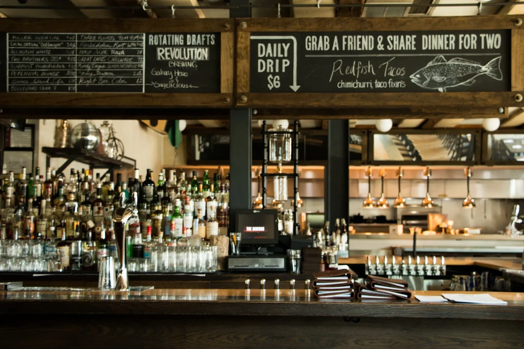 Well-stocked bar with beer taps and chalkboards listing specials.