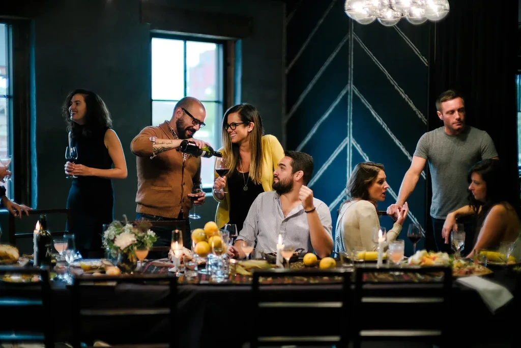 People gather at a long table in a restaurant.