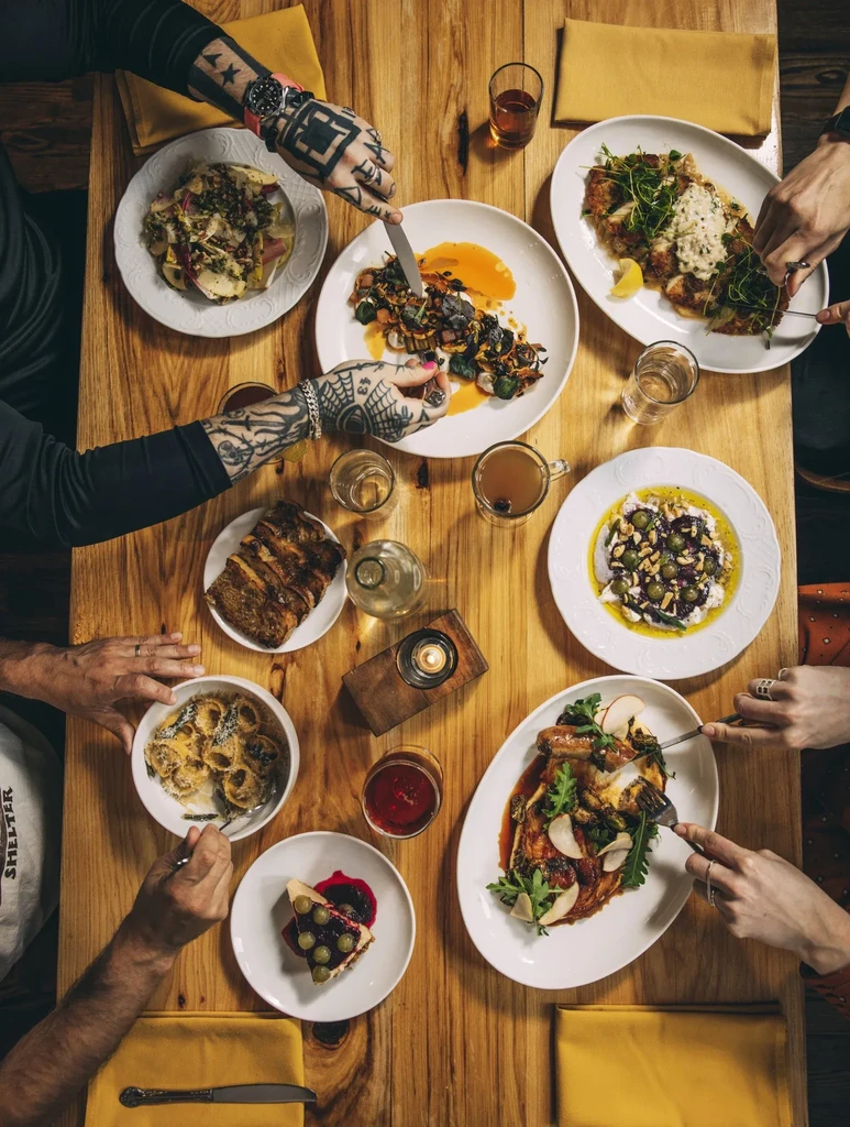 Overhead view of a dining table laden with food and drinks.