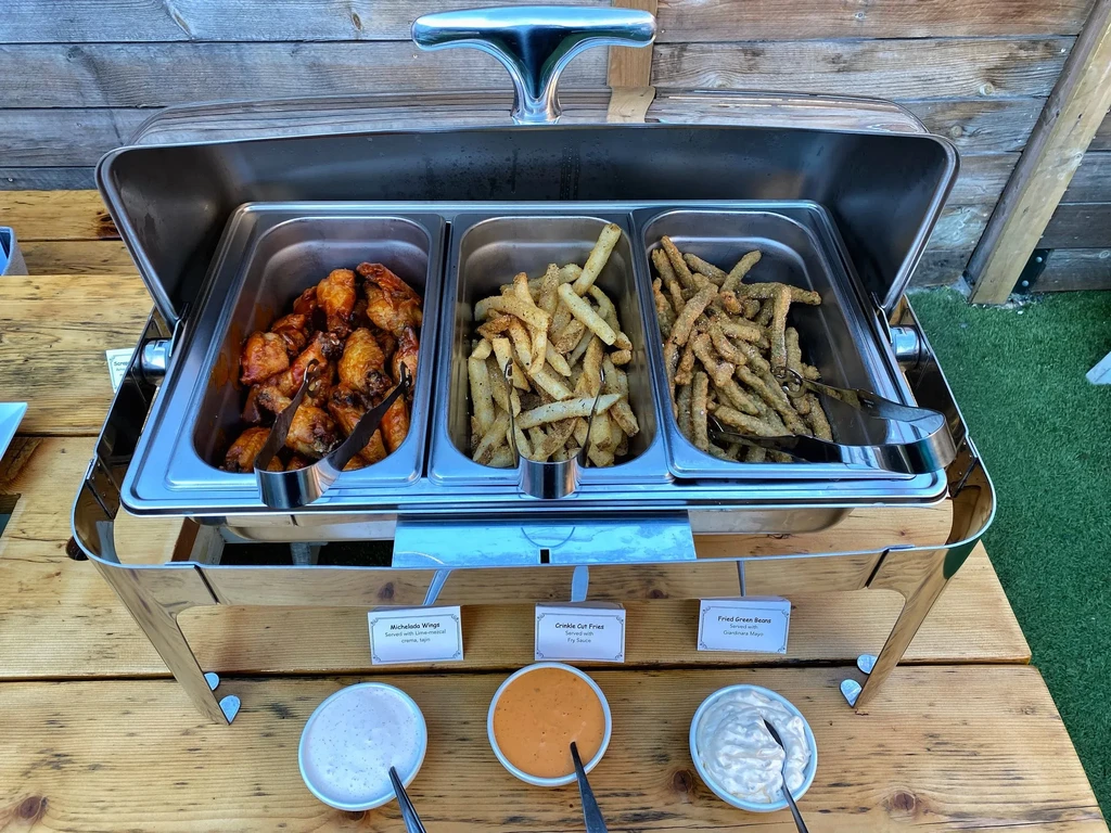 Buffet with chicken wings, fries, and fried green beans.