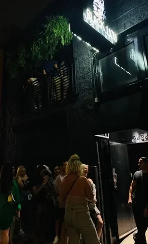 Dark building exterior with "BLACK LION" sign and people outside.