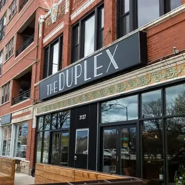 Red brick building with "THE DUPLEX" sign above the entrance.