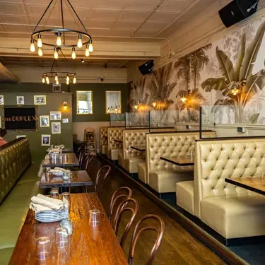Interior of The Duplex restaurant with communal table and booth seating.