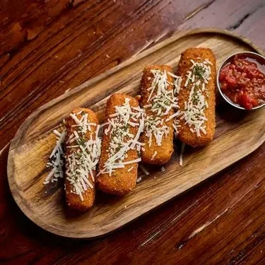 Four fried food sticks topped with cheese and herbs, with marinara.