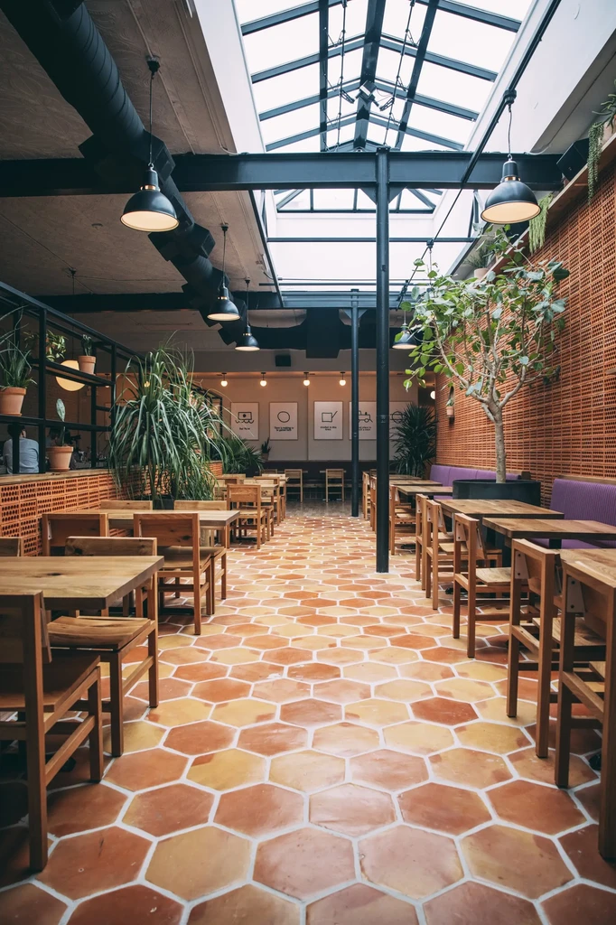 Restaurant interior with hexagonal terracotta tiles and skylights.