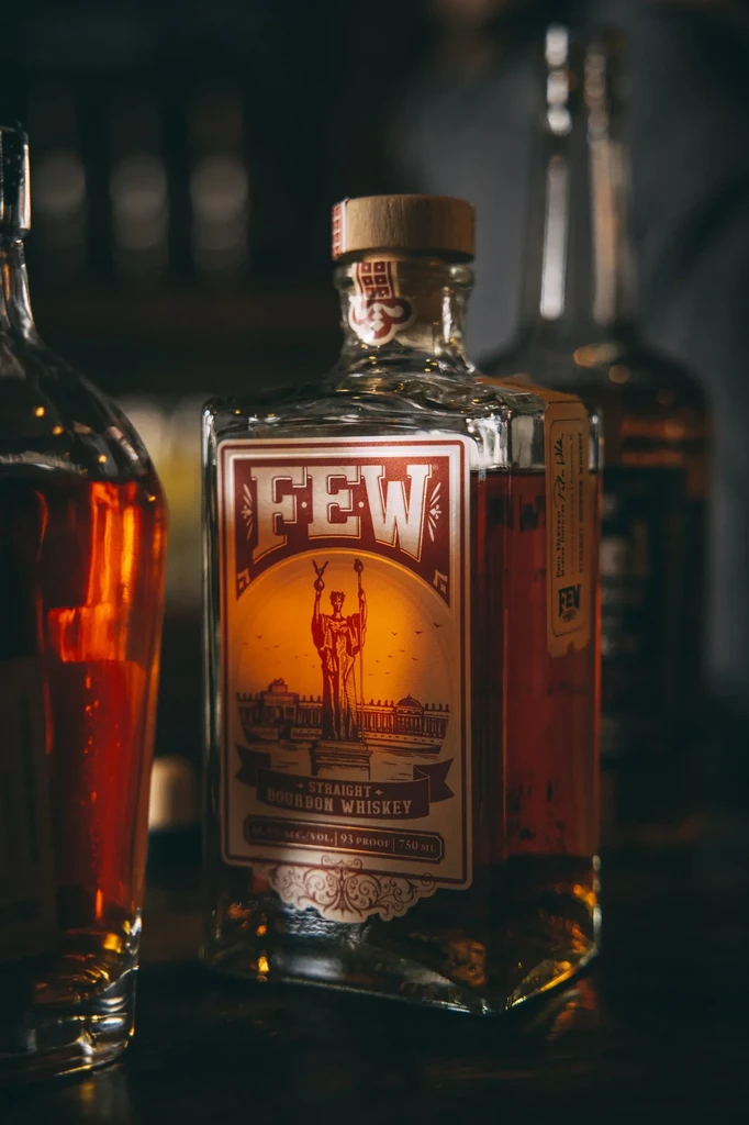 FEW Straight Bourbon Whiskey bottle on a dark, reflective surface.
