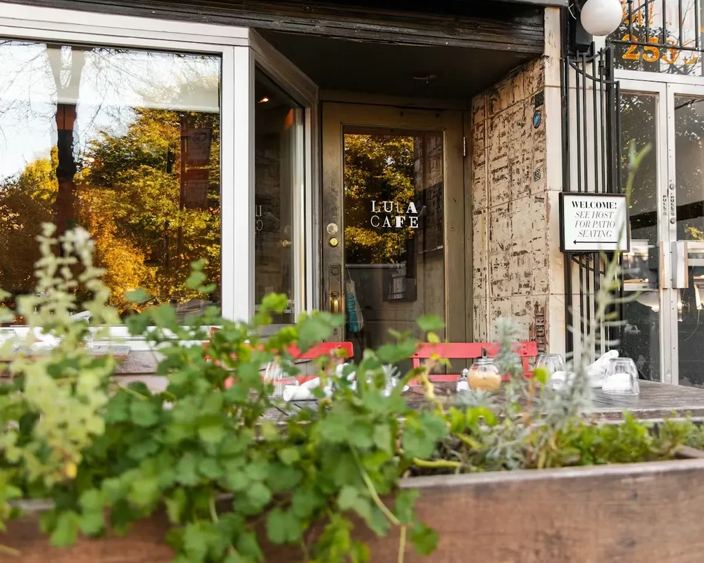 LULA CAFE exterior with patio seating and autumn reflections.