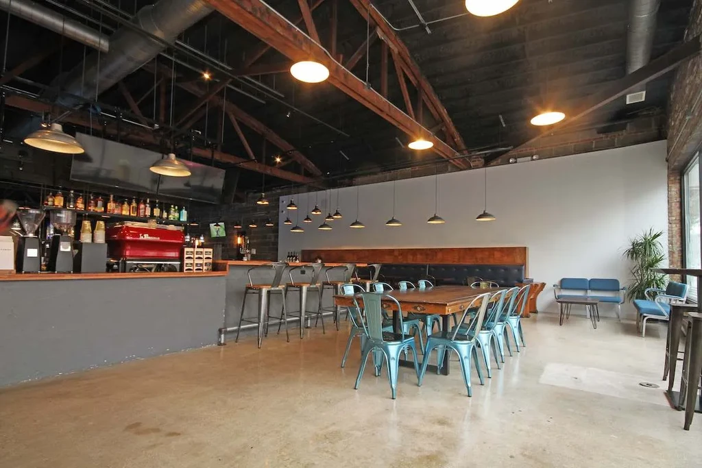 Interior of a modern industrial-style restaurant with bar and seating.