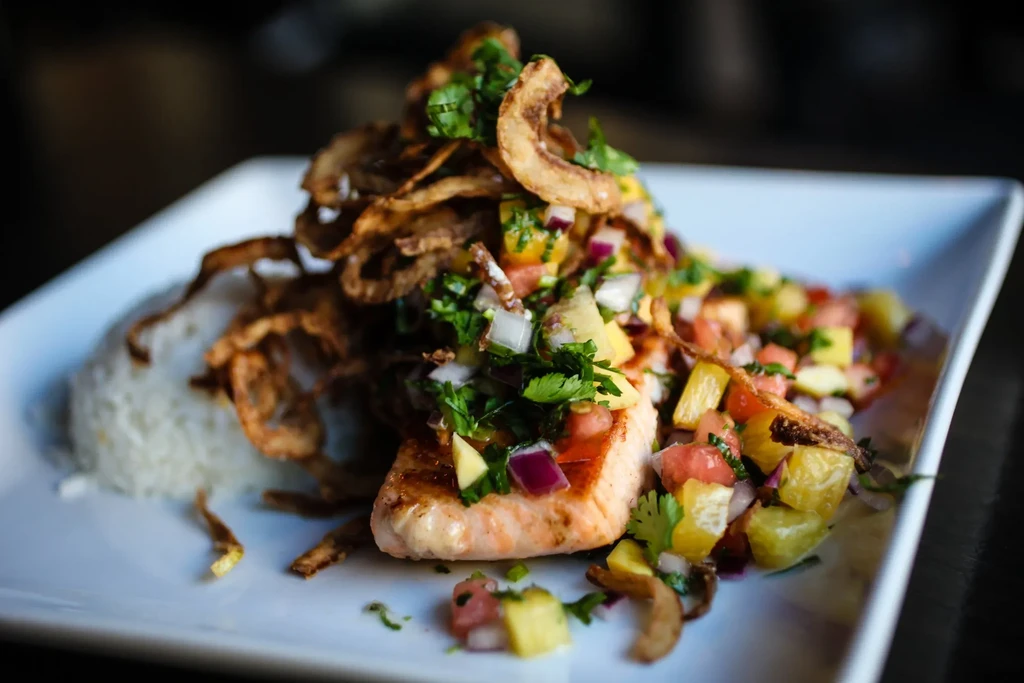 Grilled salmon, rice, and salsa on a white rectangular plate.