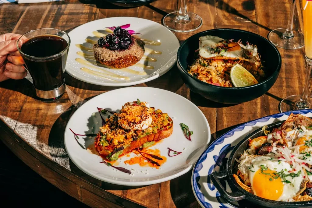 Rustic wooden table laden with diverse breakfast and brunch dishes.