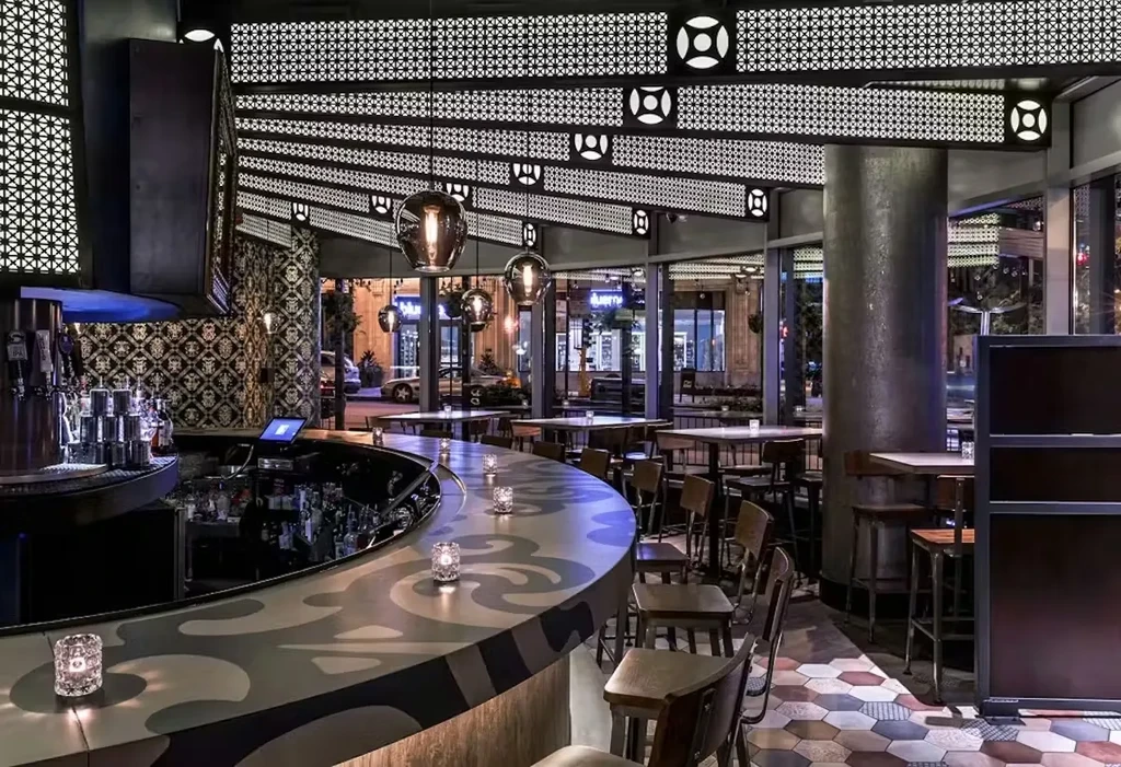 Interior of a modern bar with a curved counter and dim lighting.