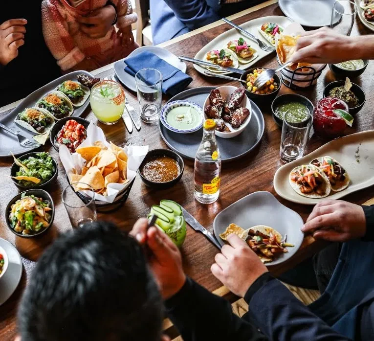 Elevated view of a wooden table with Mexican food and drinks.