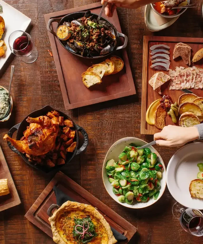 Overhead shot of a rustic table laden with food and drinks.