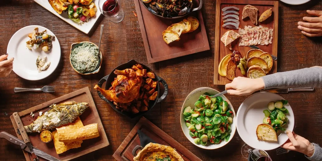 Top-down view of a wooden table laden with various dishes.