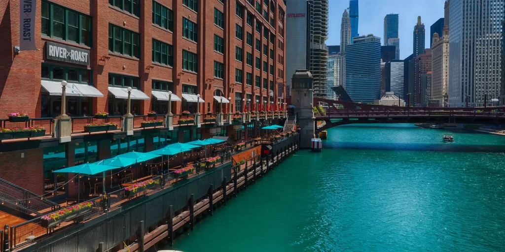 River Roast restaurant patio with turquoise umbrellas along a teal river.