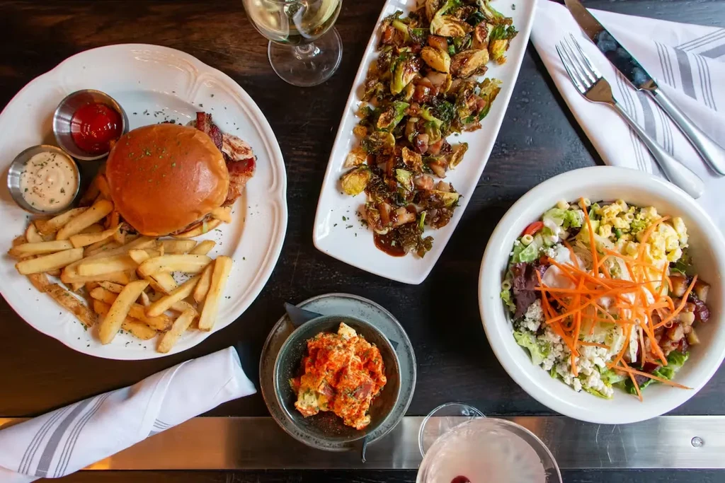 Overhead shot of a table with a burger, salad, and drinks.