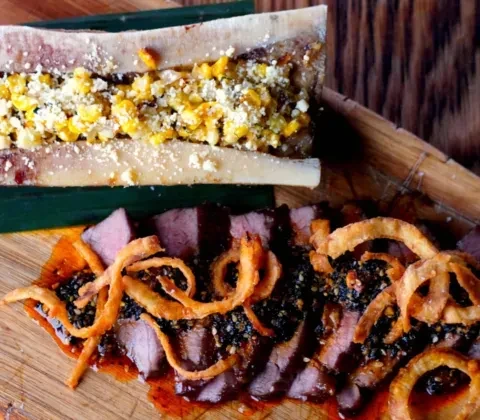 Roasted bone marrow with corn and meat with crispy onions.