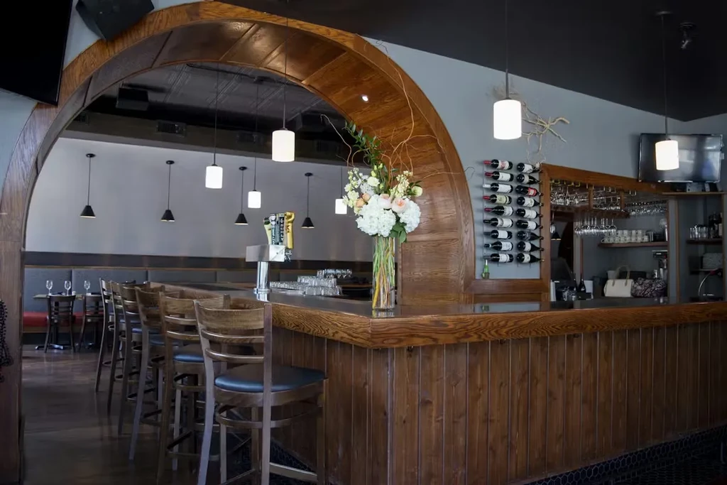 Well-appointed wooden bar with beer taps, wine rack, and flower bouquet.