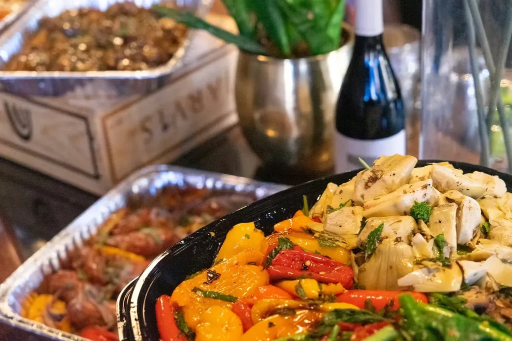 Roasted vegetables and marinated artichoke hearts on a buffet table.