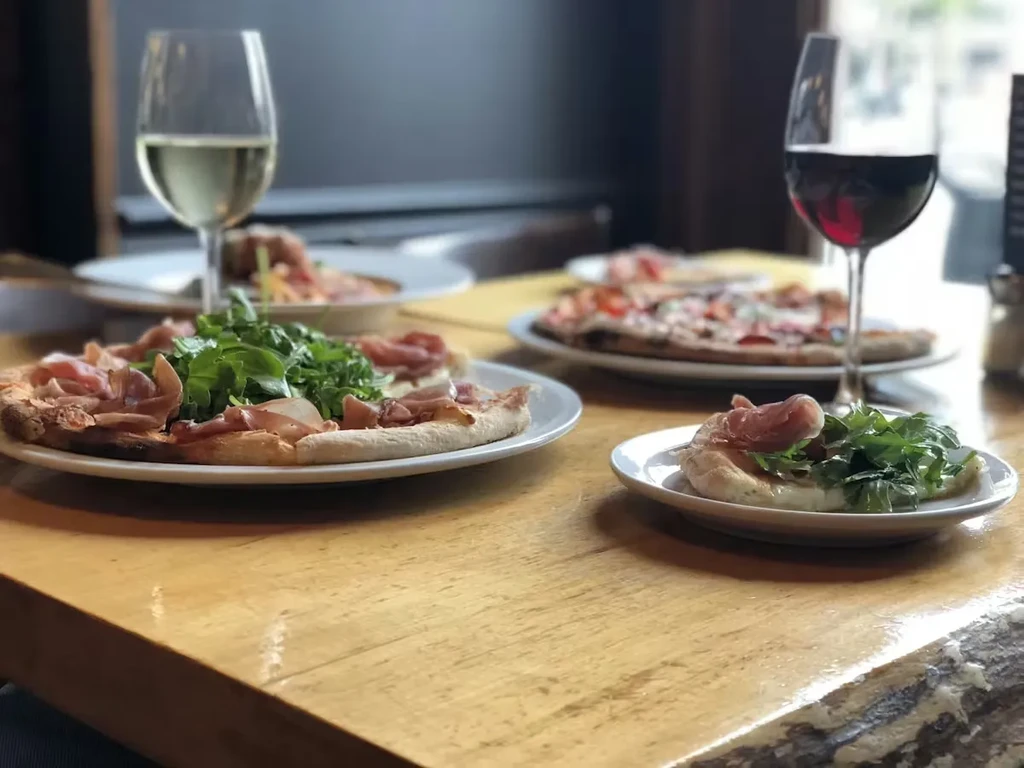 Flatbread with prosciutto and arugula, white and red wine.