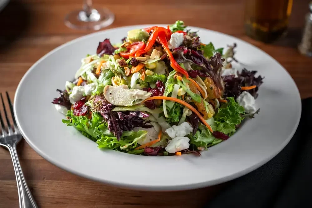 Salad with grilled chicken, vegetables, cranberries, nuts, and goat cheese.