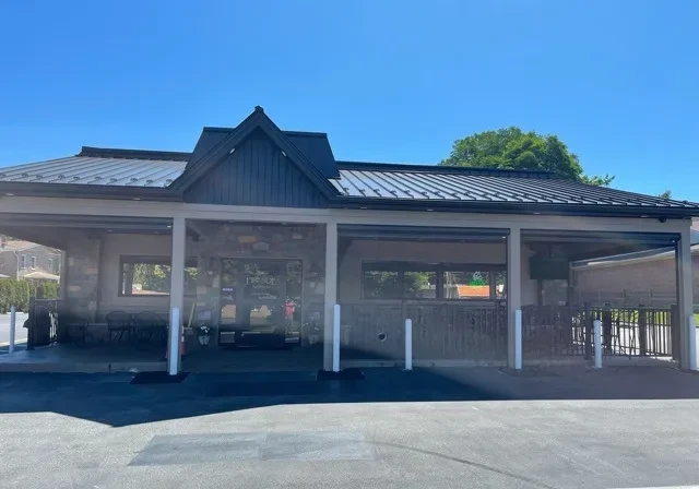 Exterior of Fireside restaurant with stone, dark siding, and covered patio.