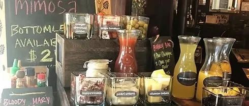 Self-serve mimosa and Bloody Mary bar with juices and garnishes.