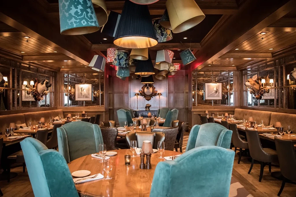 Upscale dining room featuring varied lampshades, wood paneling, and animal decor.