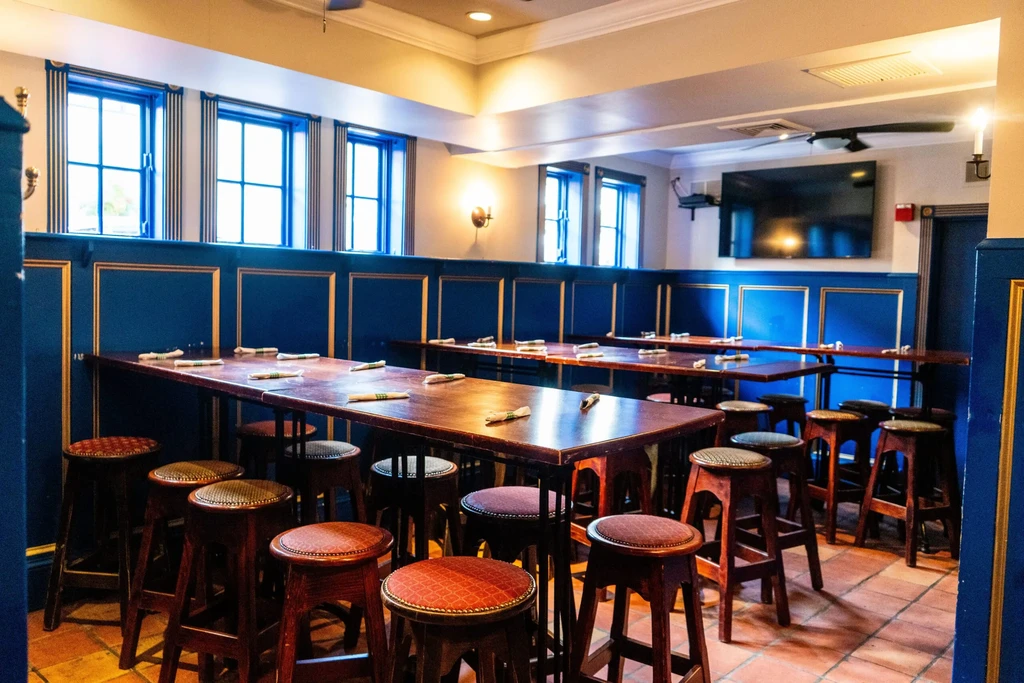 Classic restaurant interior with blue walls, high-top tables, and patterned stools.
