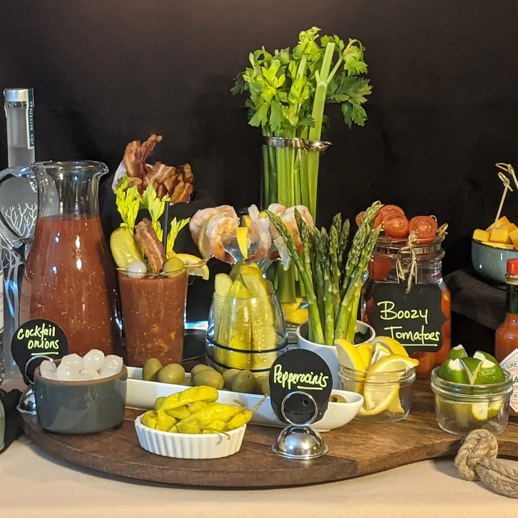 A Bloody Mary bar with prepared drink, vodka, and various garnishes.
