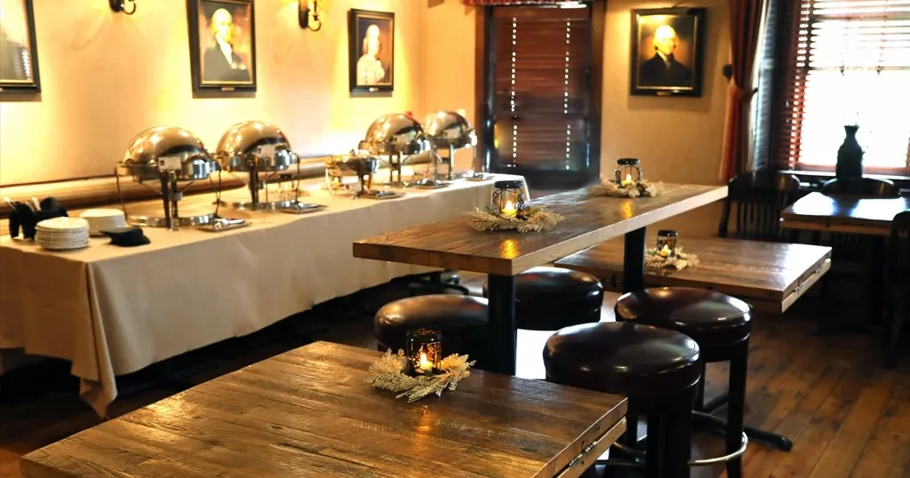Warm, rustic restaurant interior with buffet line and high-top seating.